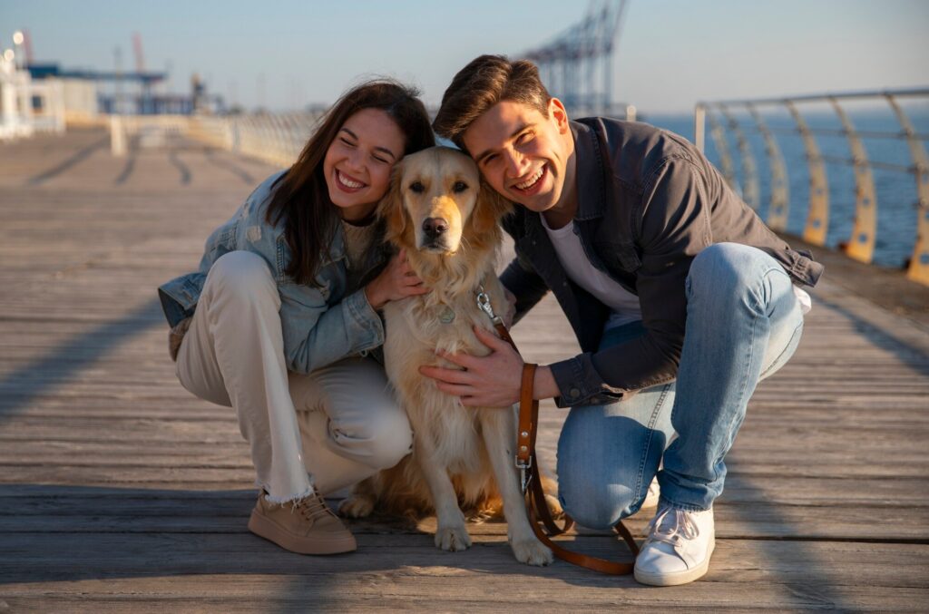 Couple avec un chien sur un pont au bord de mer