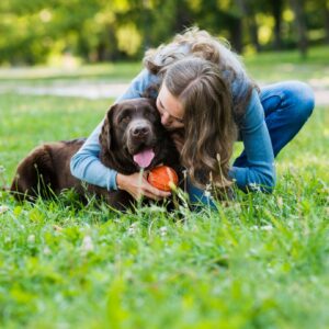 femme avec un chien sur l'herbe