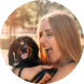 Image d'une femme avec son chien dans les bras à l'extérieur